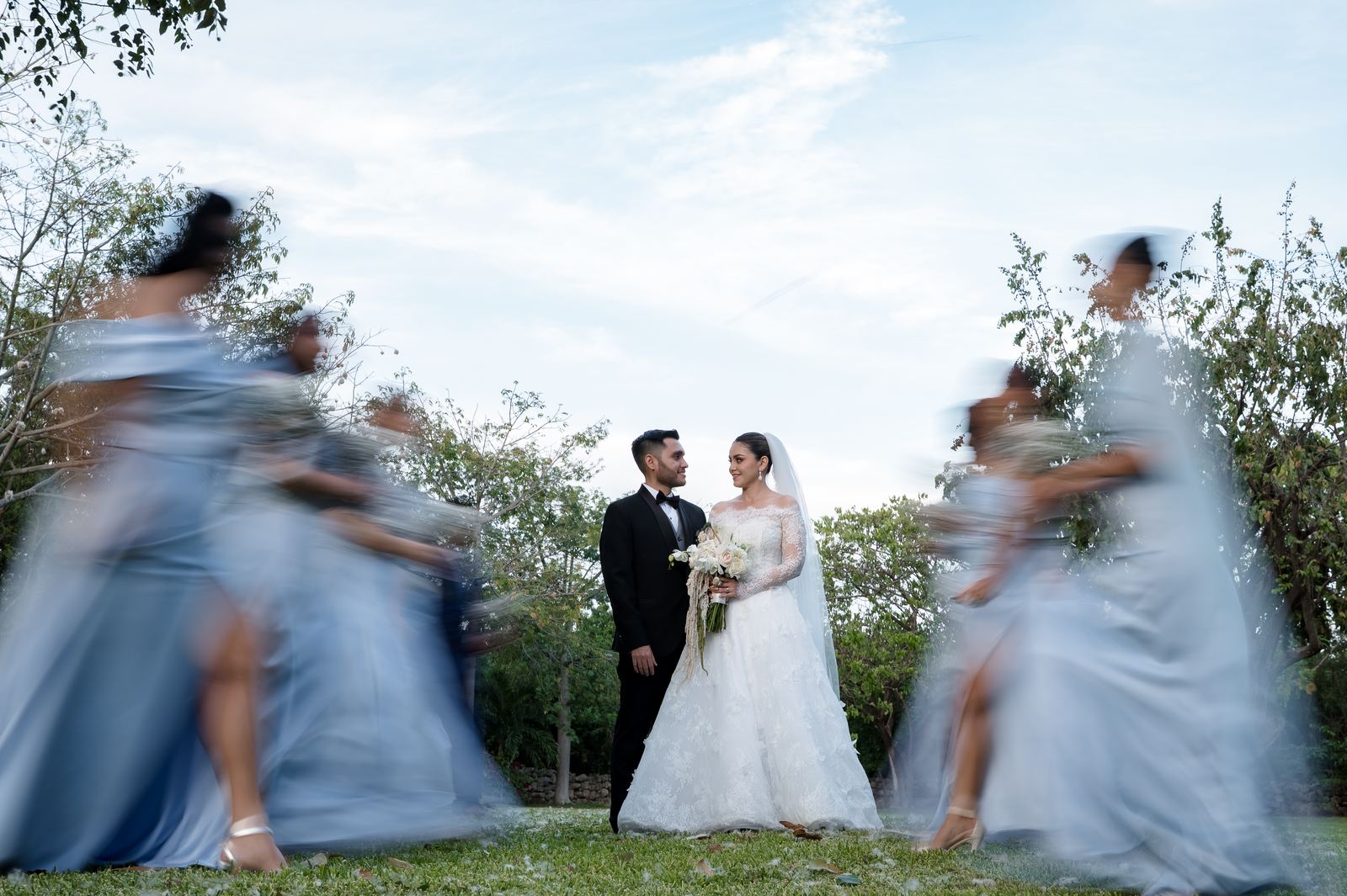 Los novios quietos mientras las damas giran a su alrededor con efecto de movimiento