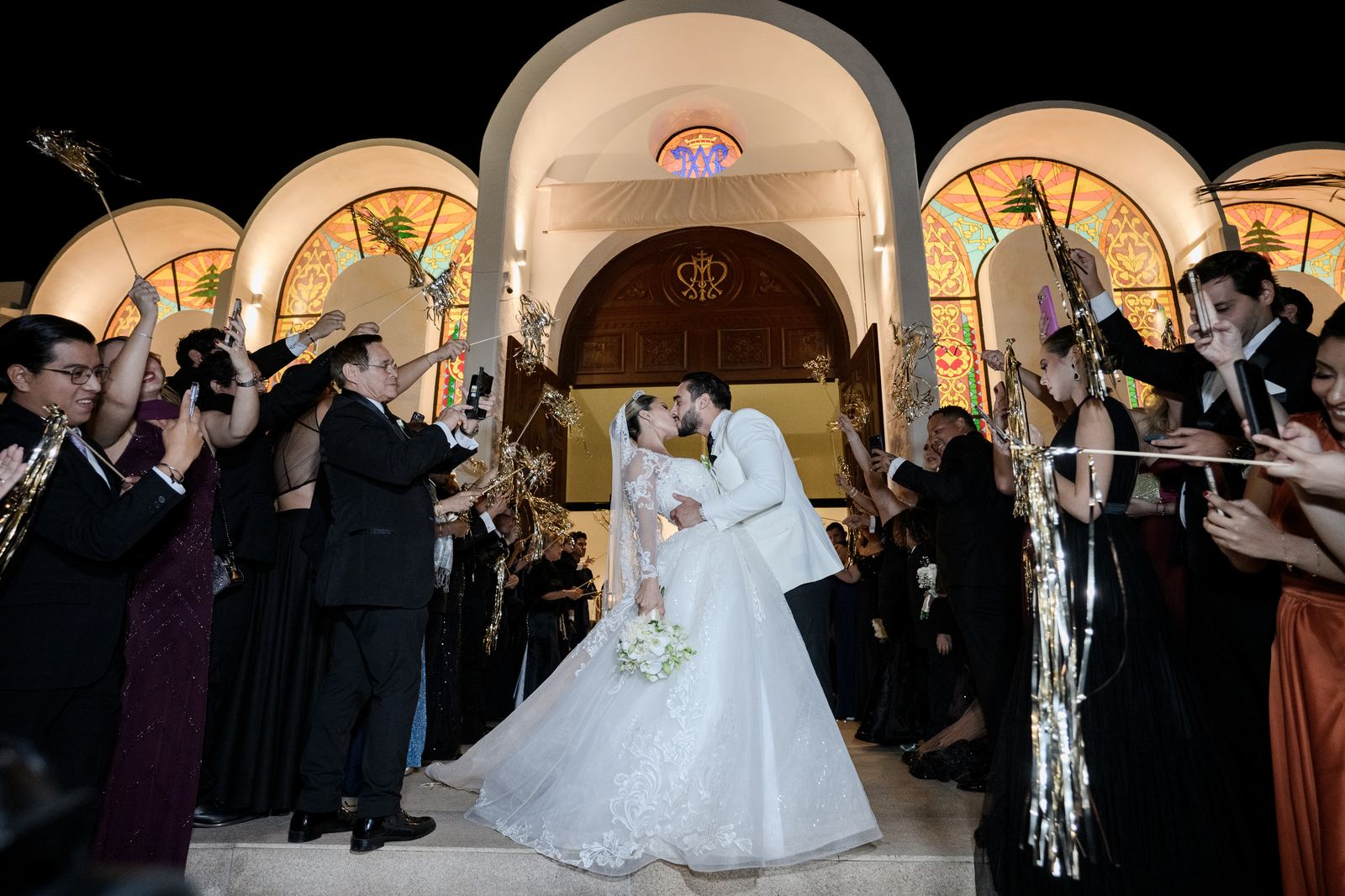 Los novios se besan a la salida de la iglesia entre bengalas y aplausos de los invitados